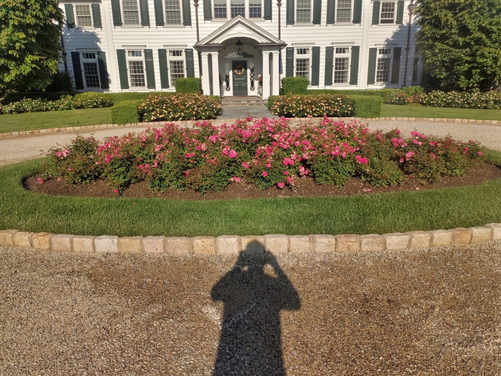 Finished rose circle island and manicured lawn framing the bluestone entry walk of a Basking Ridge estate