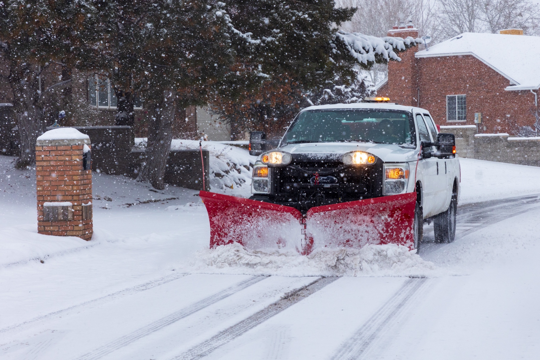 Plow truck clearing a snow-covered residential street during a New Jersey snowstorm